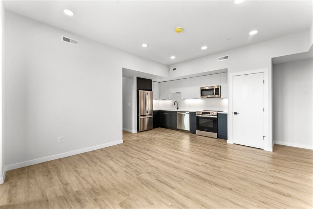 Empty room, Interior, Kitchen, Recessed Lighting, Stainless Steel Appliances, Wood Texture Flooring