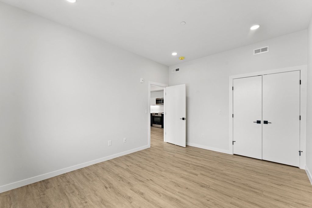Empty room, Interior, Kitchen, Recessed Lighting, Stainless Steel Appliances, Wood Texture Flooring