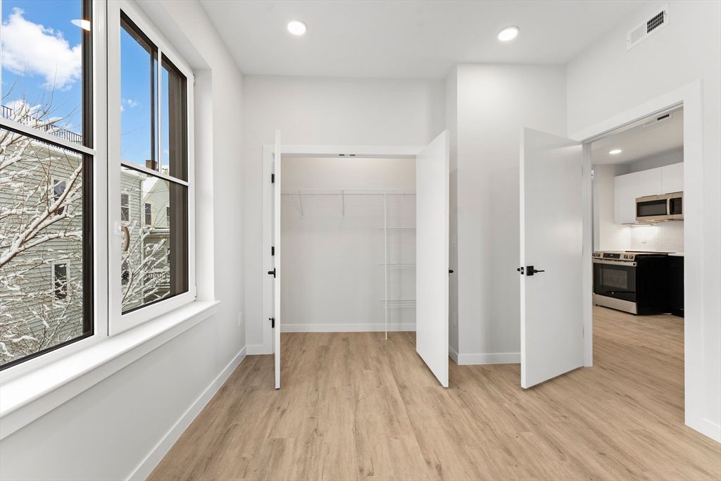 Empty room, Interior, Kitchen, Recessed Lighting, Stainless Steel Appliances, Wood Texture Flooring