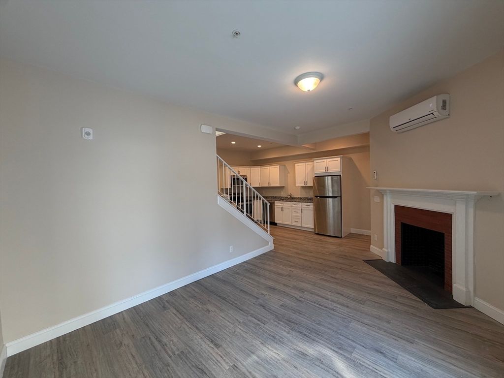 Empty room, Fireplace, Interior, Kitchen, Recessed Lighting, Stainless Steel Appliances, Wood Texture Flooring