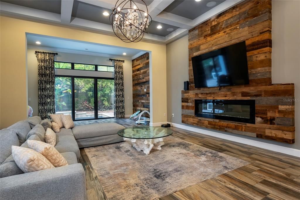 Chandelier, Fireplace, Interior, Living room, Pendant Lights, Recessed Lighting, Wood Texture Flooring, Wooden Walls