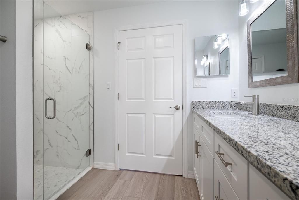 Bathroom, Dual Sink Vanities, Glass Shower, Interior, Marble Walls, Wood Texture Flooring
