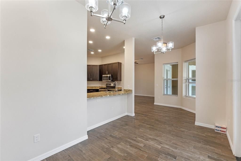 Chandelier, Empty room, Interior, Kitchen, Pendant Lights, Recessed Lighting, Stainless Steel Appliances, Wood Texture Flooring