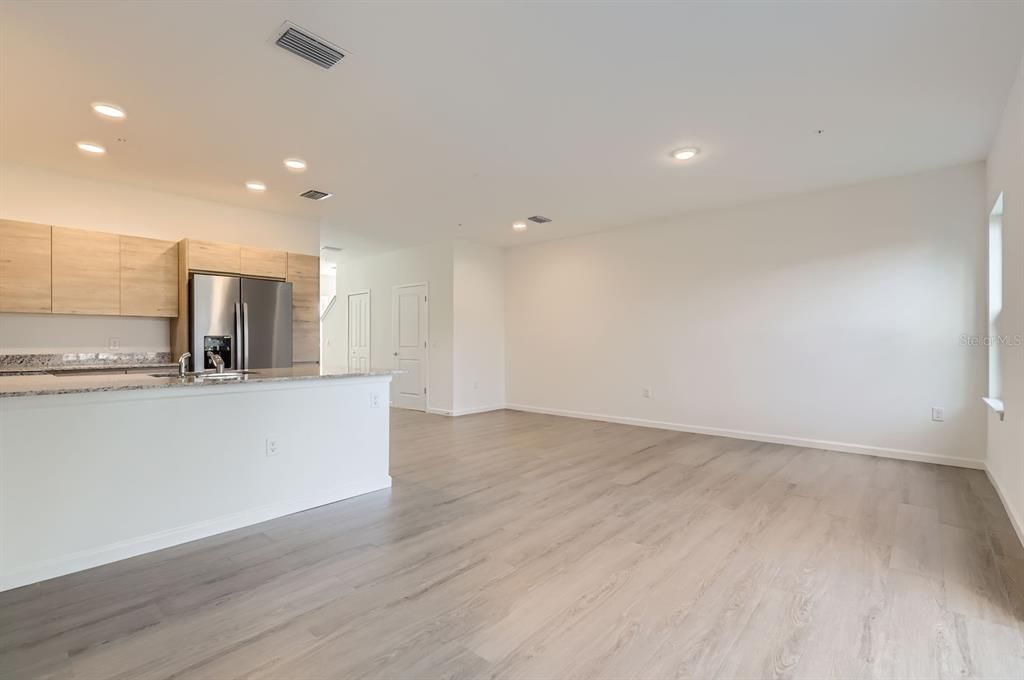 Empty room, Interior, Kitchen, Recessed Lighting, Stainless Steel Appliances, Wood Texture Flooring