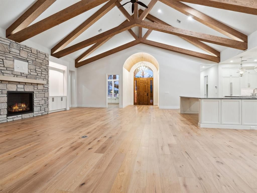 Chandelier, Empty room, Fireplace, Interior, Pendant Lights, Recessed Lighting, Stone Walls, Wooden Beams, Wood Texture Flooring
