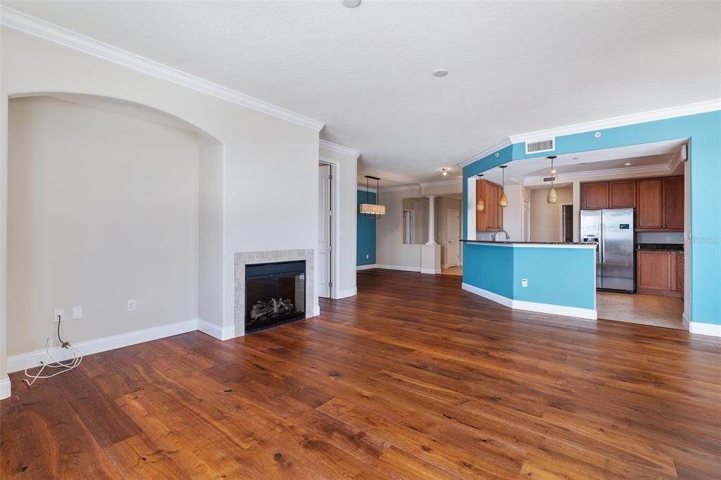 Empty room, Fireplace, Interior, Kitchen, Pendant Lights, Recessed Lighting, Stainless Steel Appliances, Wood Texture Flooring