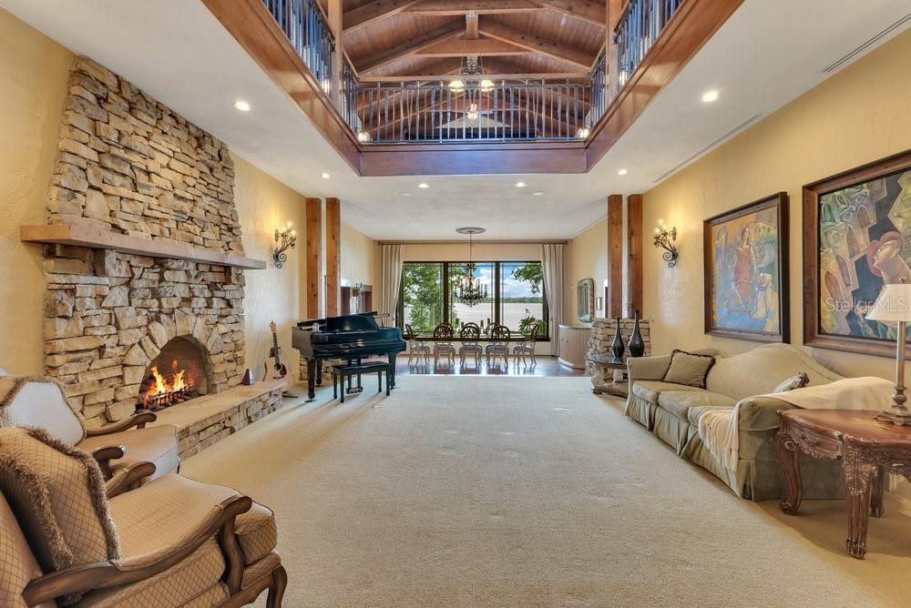 Chandelier, Fireplace, Interior, Living room, Piano, Recessed Lighting, Stone Walls, Wooden Beams