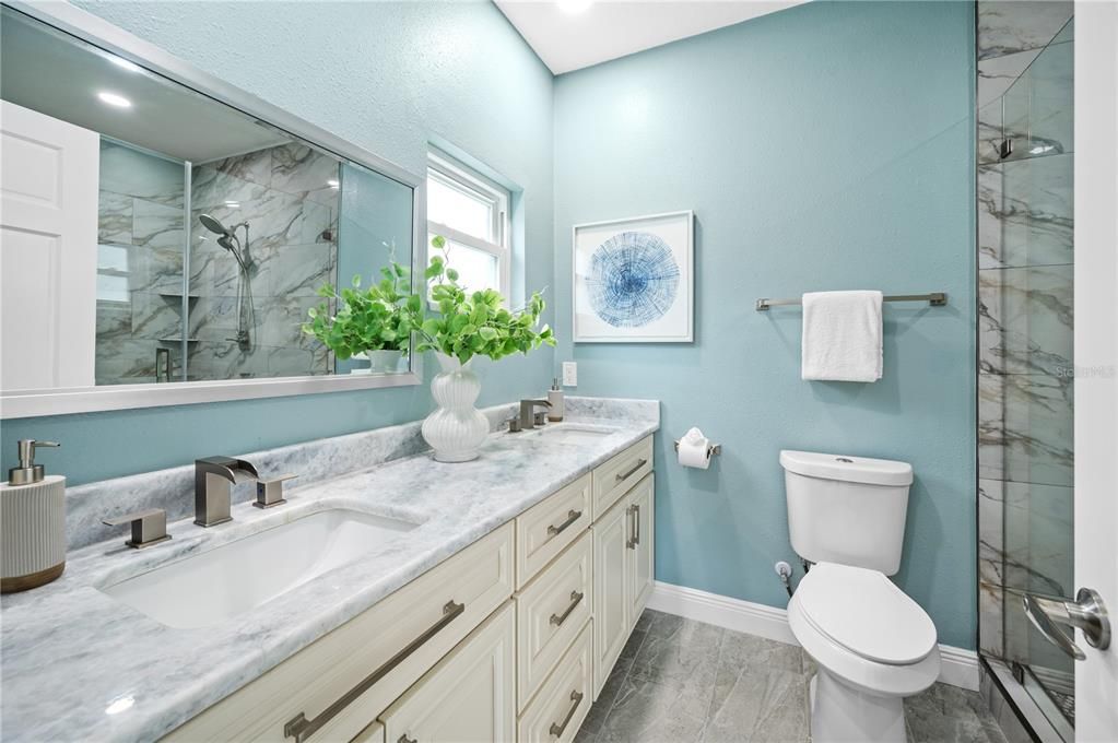 Bathroom, Dual Sink Vanities, Glass Shower, Interior, Marble Walls, Recessed Lighting, Wood Texture Flooring