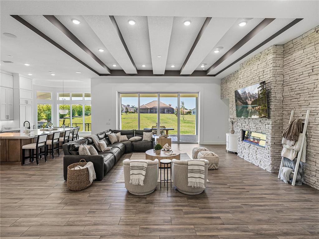 Dining room, Fireplace, Interior, Living room, Recessed Lighting, Stone Walls, Wood Texture Flooring