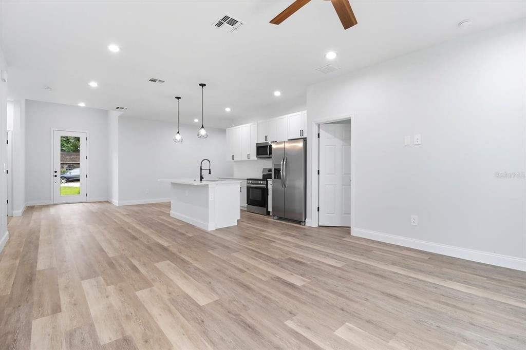 Empty room, Interior, Kitchen, Pendant Lights, Recessed Lighting, Stainless Steel Appliances, Wood Texture Flooring