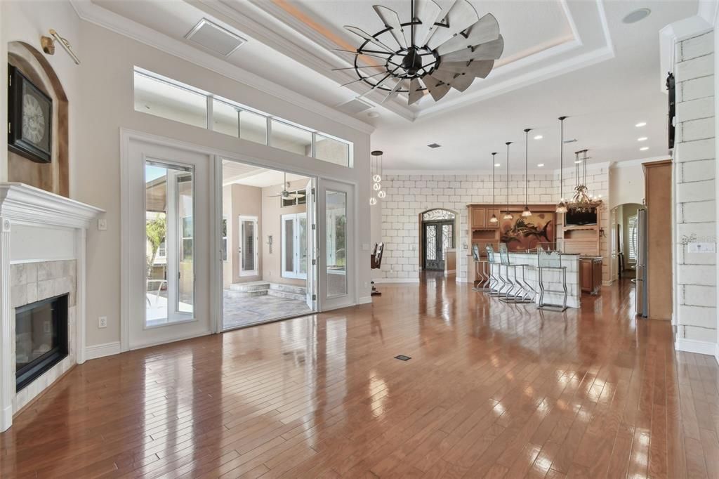 Empty room, Fireplace, Interior, Kitchen, Pendant Lights, Recessed Lighting, Stainless Steel Appliances, Stone Walls, Wood Texture Flooring