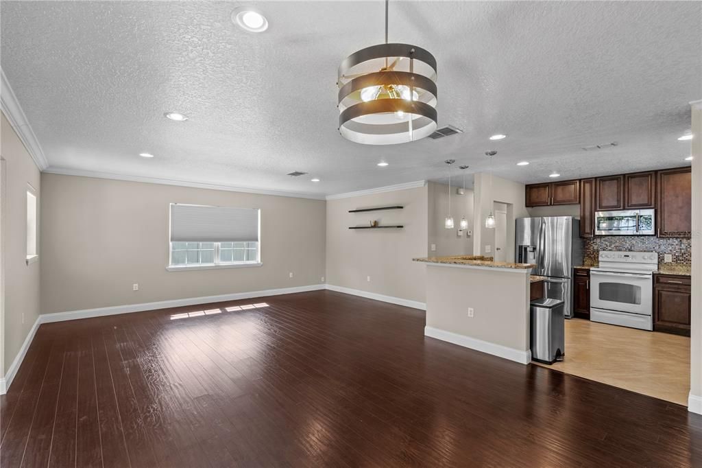 Empty room, Interior, Kitchen, Pendant Lights, Recessed Lighting, Stainless Steel Appliances, Wood Texture Flooring