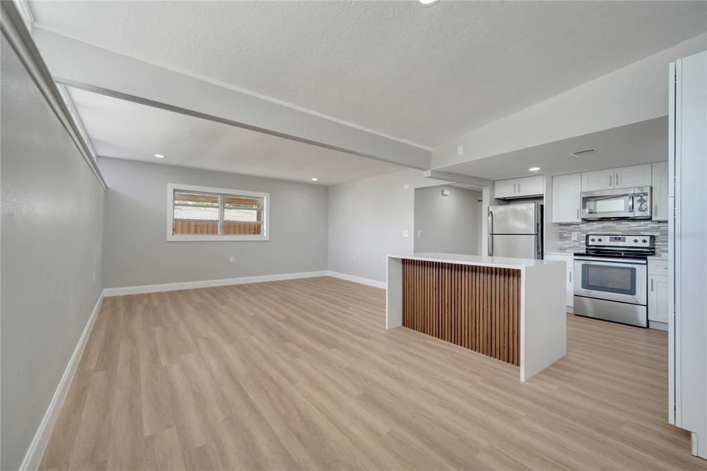 Empty room, Interior, Kitchen, Recessed Lighting, Stainless Steel Appliances, Wood Texture Flooring
