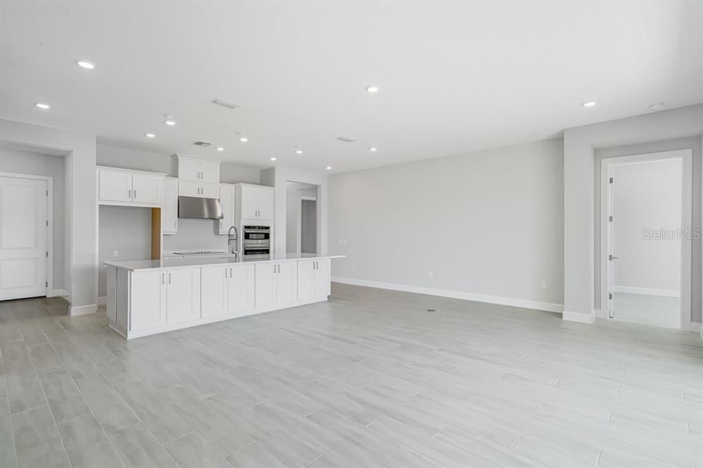Empty room, Interior, Kitchen, Recessed Lighting, Stainless Steel Appliances, Wood Texture Flooring