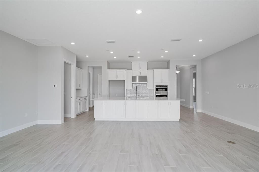 Empty room, Interior, Kitchen, Recessed Lighting, Stainless Steel Appliances, Wood Texture Flooring