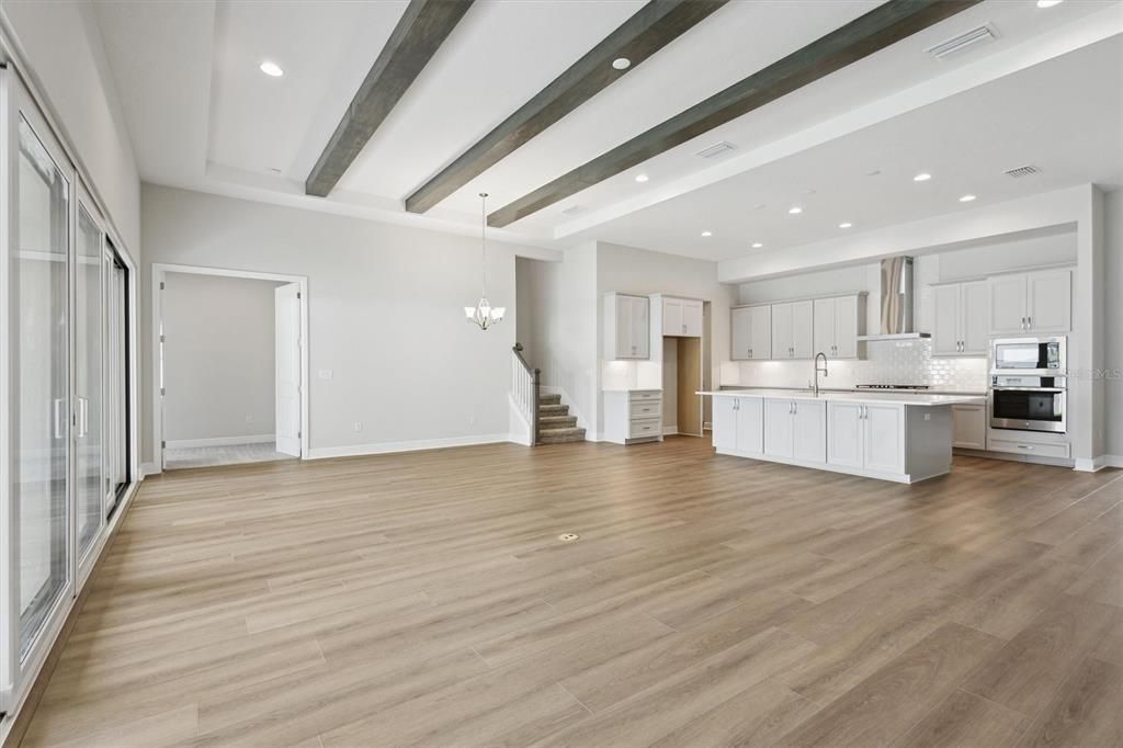 Chandelier, Empty room, Interior, Kitchen, Pendant Lights, Recessed Lighting, Stainless Steel Appliances, Wooden Beams, Wood Texture Flooring