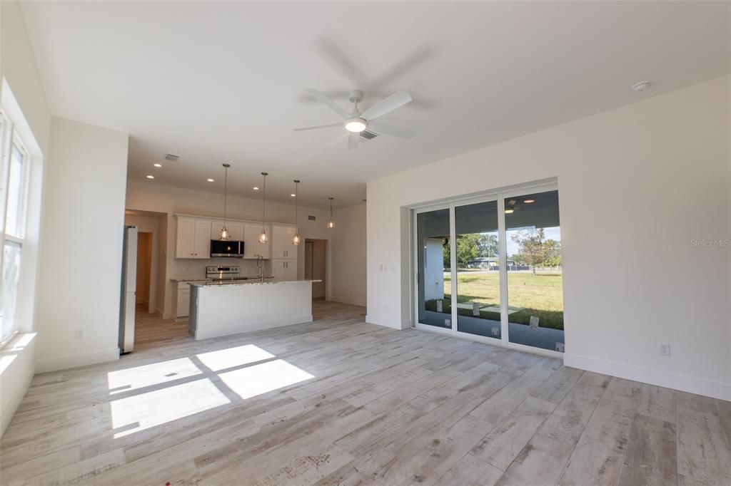 Empty room, Interior, Kitchen, Pendant Lights, Recessed Lighting, Stainless Steel Appliances, Wood Texture Flooring