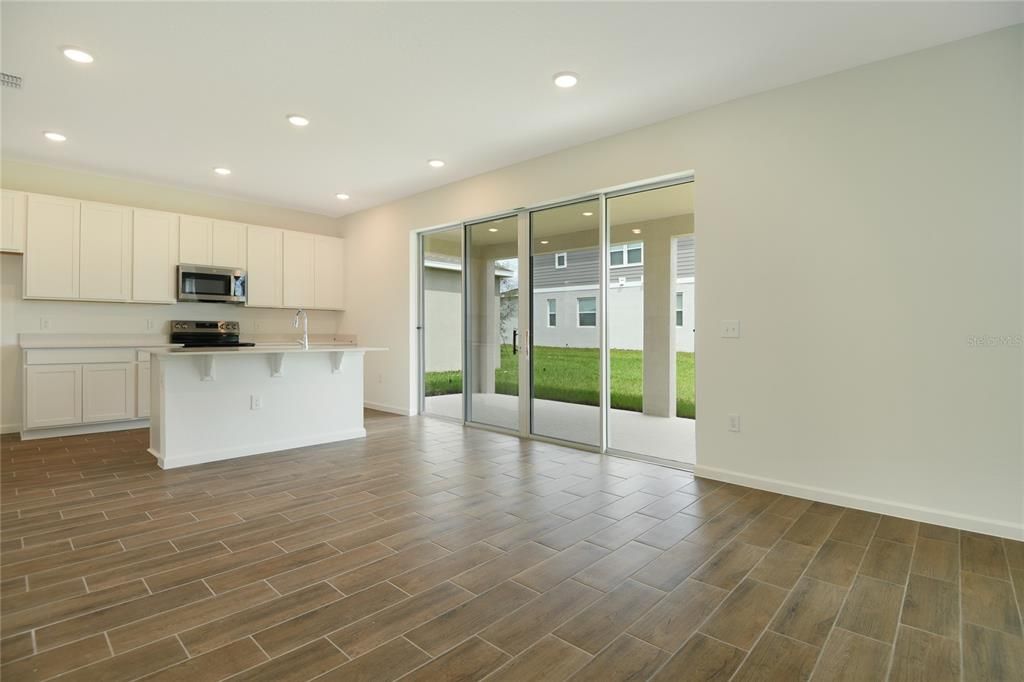 Empty room, Interior, Kitchen, Recessed Lighting, Stainless Steel Appliances, Wood Texture Flooring