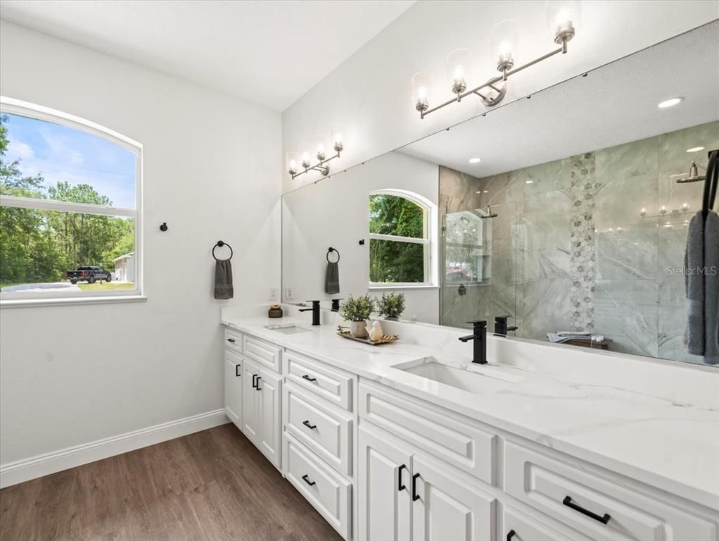 Bathroom, Dual Sink Vanities, Glass Shower, Interior, Marble Walls, Recessed Lighting, Wood Texture Flooring