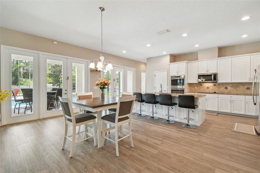Chandelier, Dining room, Interior, Kitchen, Pendant Lights, Recessed Lighting, Stainless Steel Appliances, Wood Texture Flooring