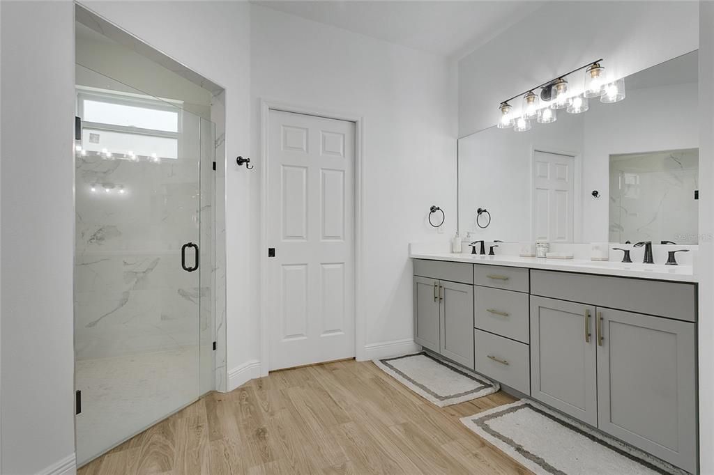 Bathroom, Dual Sink Vanities, Glass Shower, Interior, Marble Walls, Wood Texture Flooring