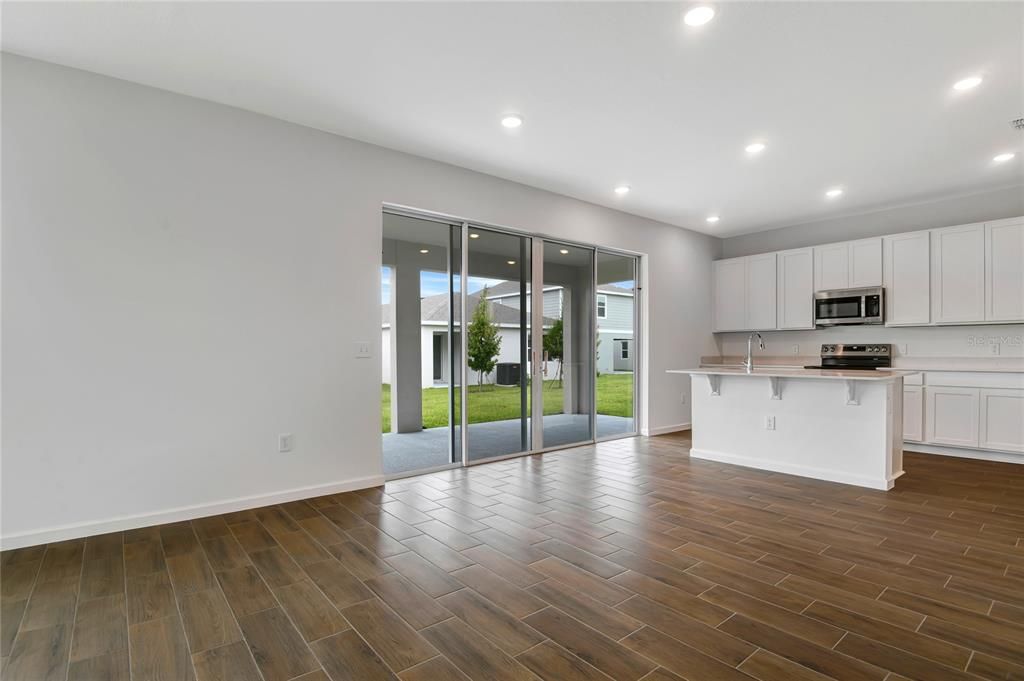 Empty room, Interior, Kitchen, Recessed Lighting, Stainless Steel Appliances, Wood Texture Flooring