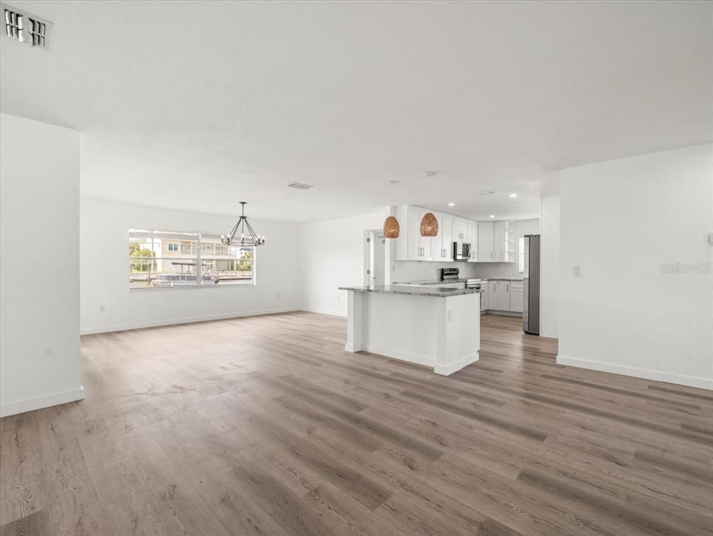 Empty room, Interior, Kitchen, Pendant Lights, Recessed Lighting, Stainless Steel Appliances, Wood Texture Flooring