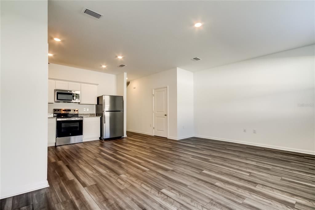 Empty room, Interior, Kitchen, Recessed Lighting, Stainless Steel Appliances, Wood Texture Flooring