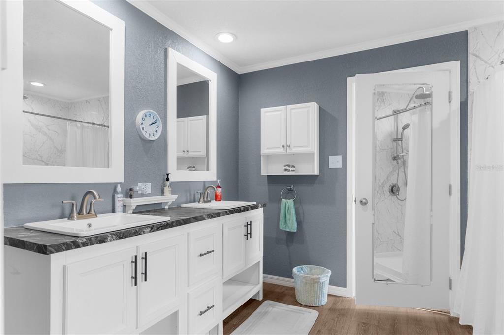 Bathroom, Dual Sink Vanities, Glass Shower, Interior, Marble Walls, Recessed Lighting, Wood Texture Flooring