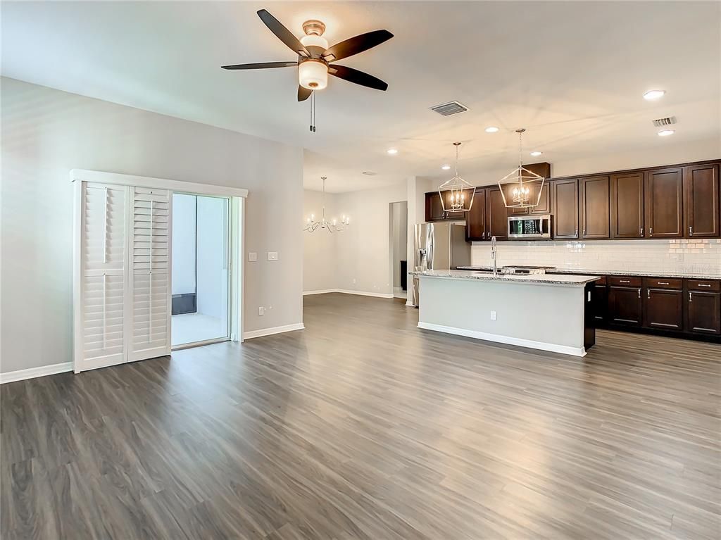 Chandelier, Empty room, Interior, Kitchen, Pendant Lights, Recessed Lighting, Stainless Steel Appliances, Wood Texture Flooring