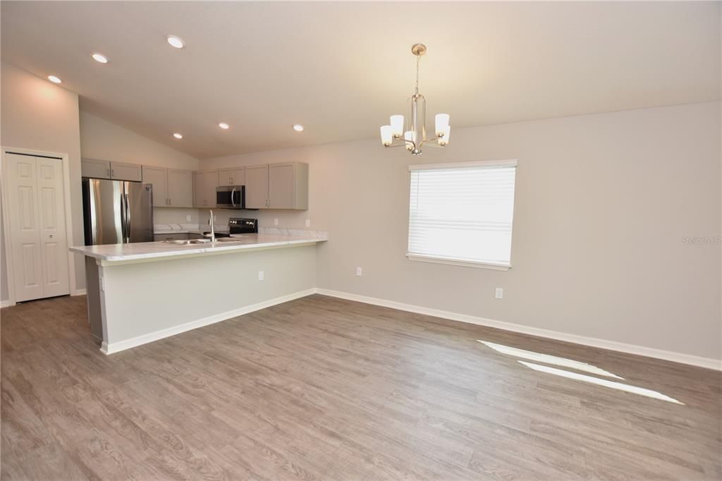 Chandelier, Empty room, Interior, Kitchen, Recessed Lighting, Stainless Steel Appliances, Wood Texture Flooring