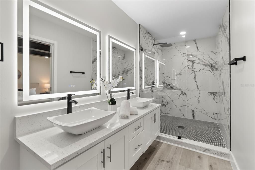 Bathroom, Dual Sink Vanities, Glass Shower, Interior, Marble Walls, Recessed Lighting, Wood Texture Flooring