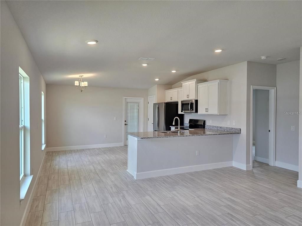 Empty room, Interior, Kitchen, Recessed Lighting, Stainless Steel Appliances, Wood Texture Flooring
