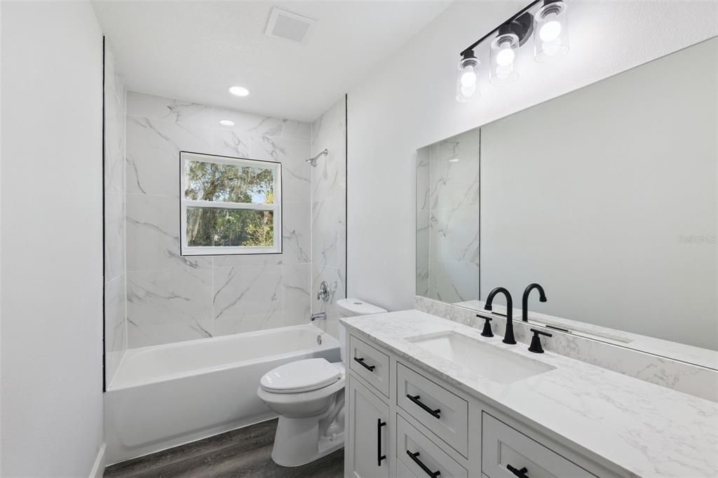Bathroom, Dual Sink Vanities, Interior, Marble Walls, Recessed Lighting, Wood Texture Flooring
