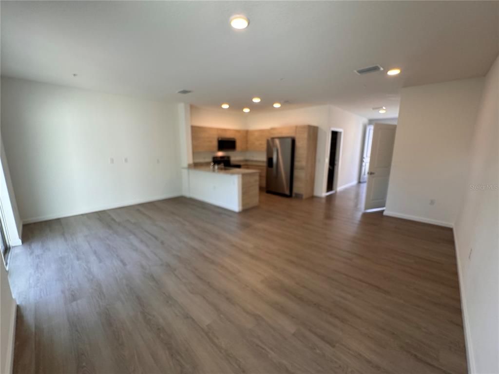 Empty room, Interior, Kitchen, Recessed Lighting, Stainless Steel Appliances, Wood Texture Flooring