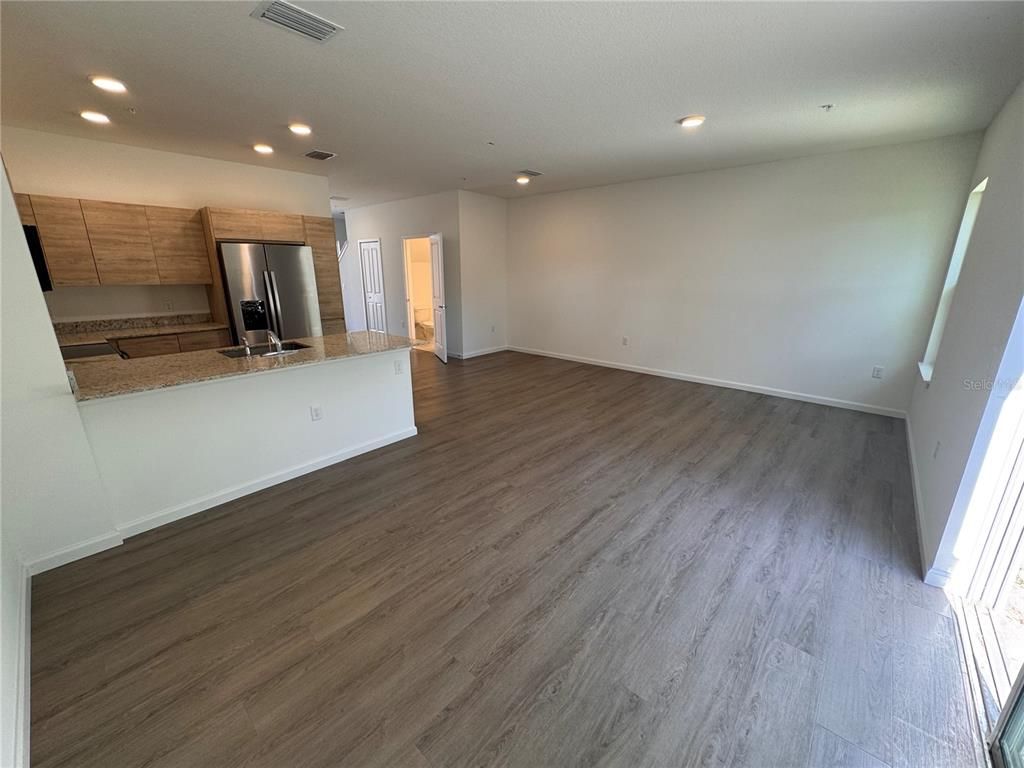 Empty room, Interior, Kitchen, Recessed Lighting, Stainless Steel Appliances, Wood Texture Flooring