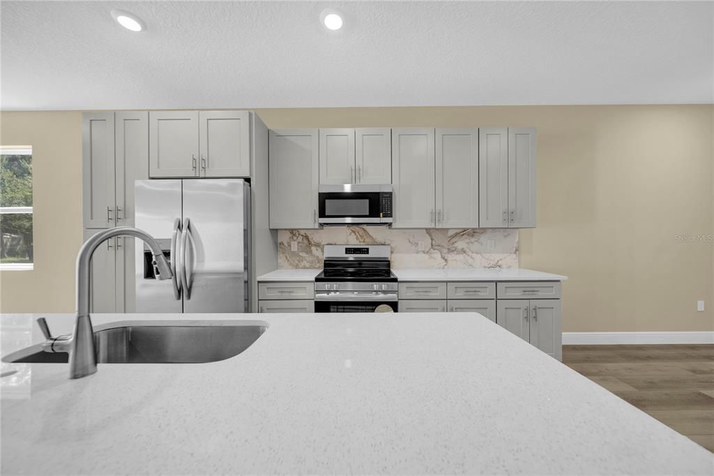 Interior, Kitchen, Marble Walls, Recessed Lighting, Stainless Steel Appliances, Wood Texture Flooring