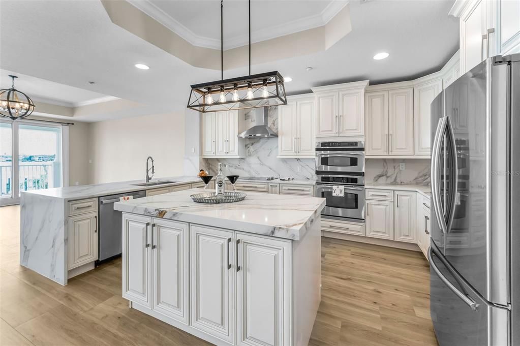 Chandelier, Interior, Kitchen, Marble Walls, Pendant Lights, Recessed Lighting, Stainless Steel Appliances, Wood Texture Flooring