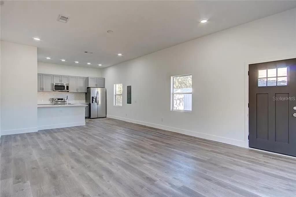Empty room, Interior, Kitchen, Recessed Lighting, Stainless Steel Appliances, Wood Texture Flooring