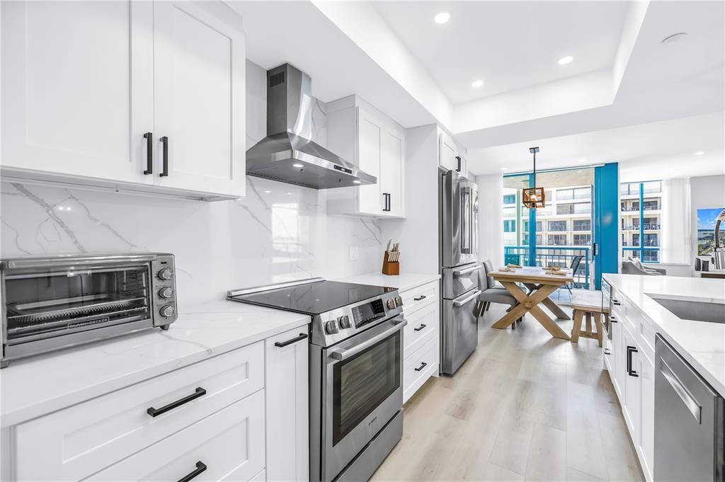 Dining room, Interior, Kitchen, Marble Walls, Pendant Lights, Recessed Lighting, Stainless Steel Appliances, Water, Wood Texture Flooring