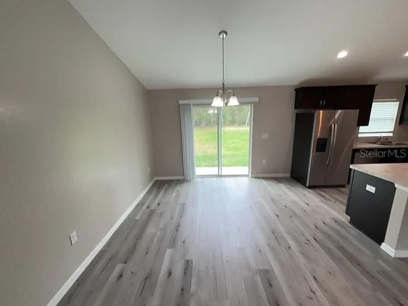 Empty room, Interior, Kitchen, Pendant Lights, Recessed Lighting, Stainless Steel Appliances, Wood Texture Flooring