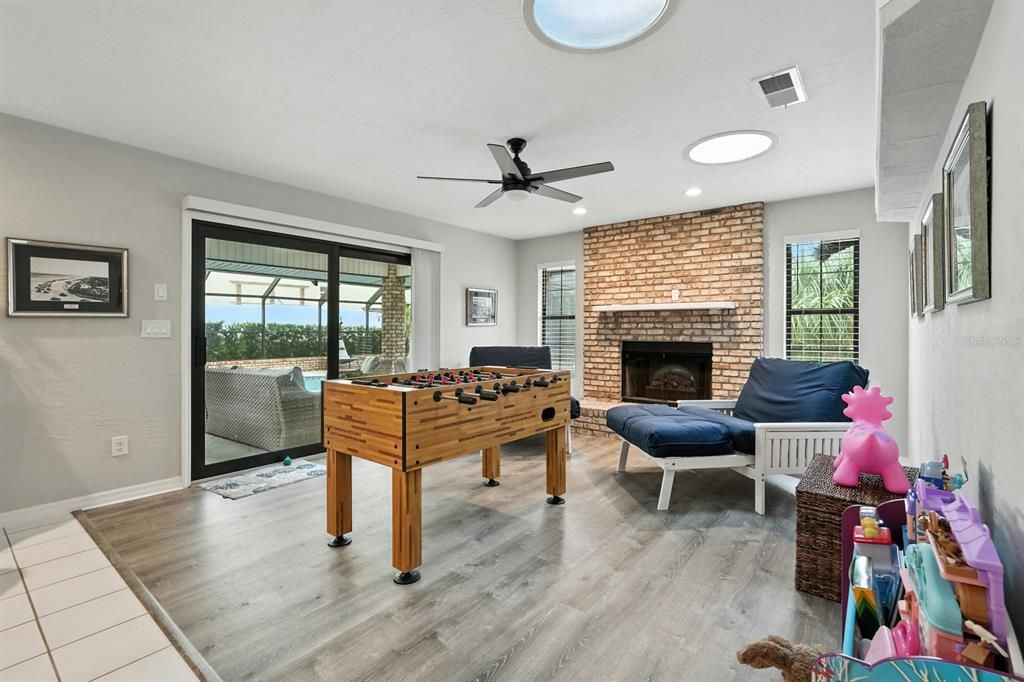 Fireplace, Game Room, Interior, Recessed Lighting, Stone Walls, Wood Texture Flooring