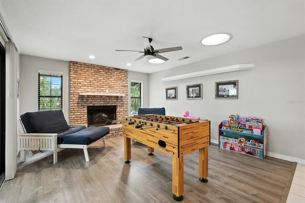 Fireplace, Game Room, Interior, Recessed Lighting, Stone Walls, Wood Texture Flooring