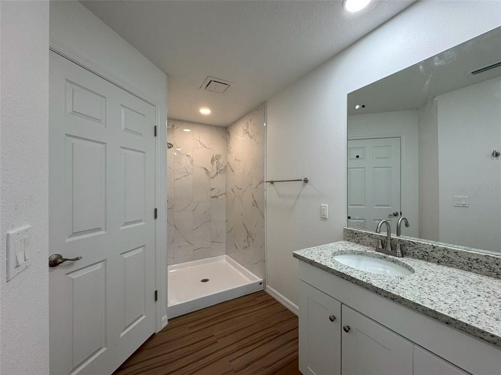 Bathroom, Dual Sink Vanities, Interior, Marble Walls, Recessed Lighting, Wood Texture Flooring