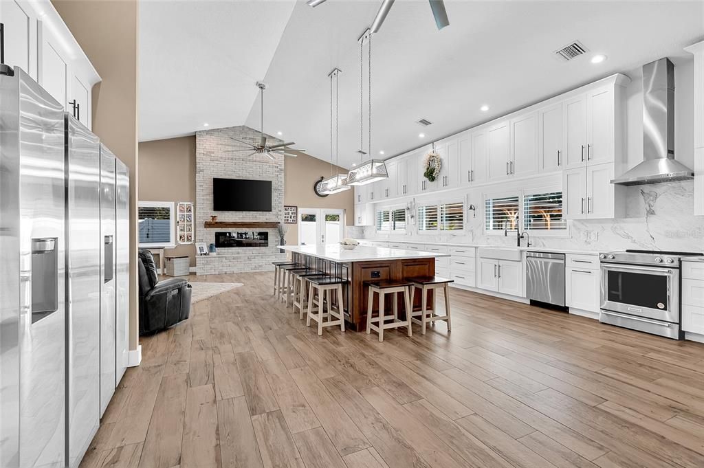 Fireplace, Interior, Kitchen, Pendant Lights, Recessed Lighting, Stainless Steel Appliances, Stone Walls, Wood Texture Flooring