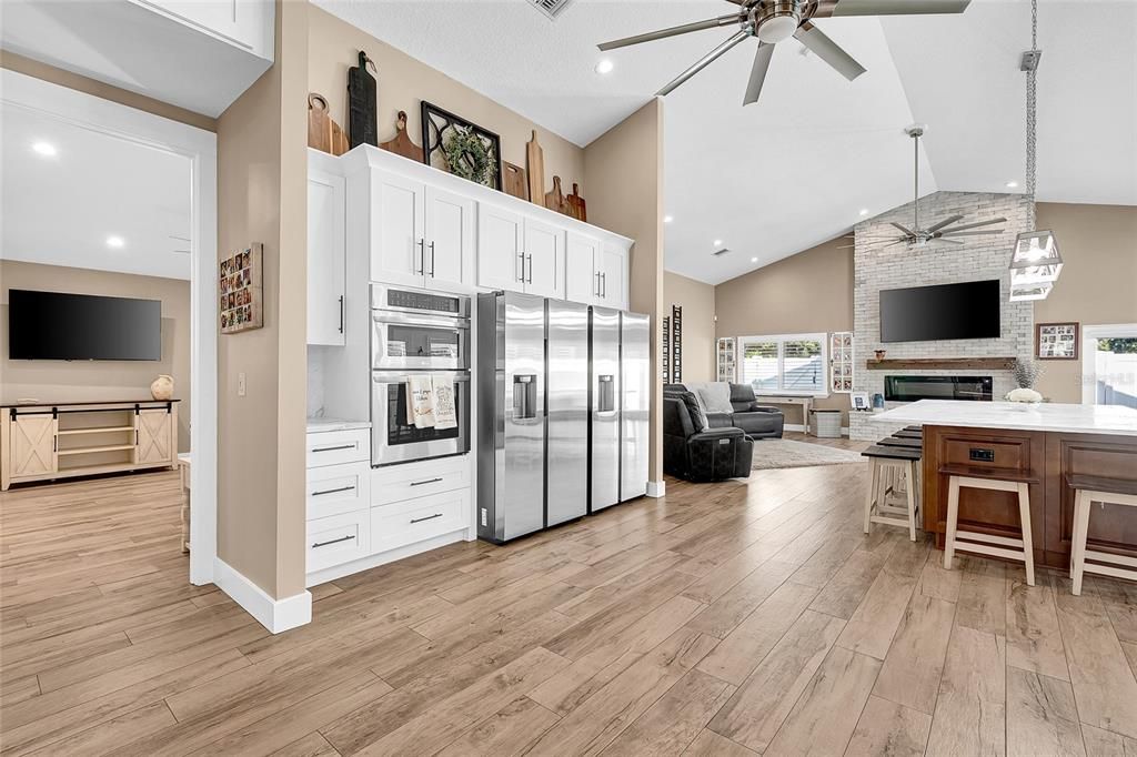 Fireplace, Interior, Kitchen, Living room, Pendant Lights, Recessed Lighting, Stainless Steel Appliances, Stone Walls, Wood Texture Flooring