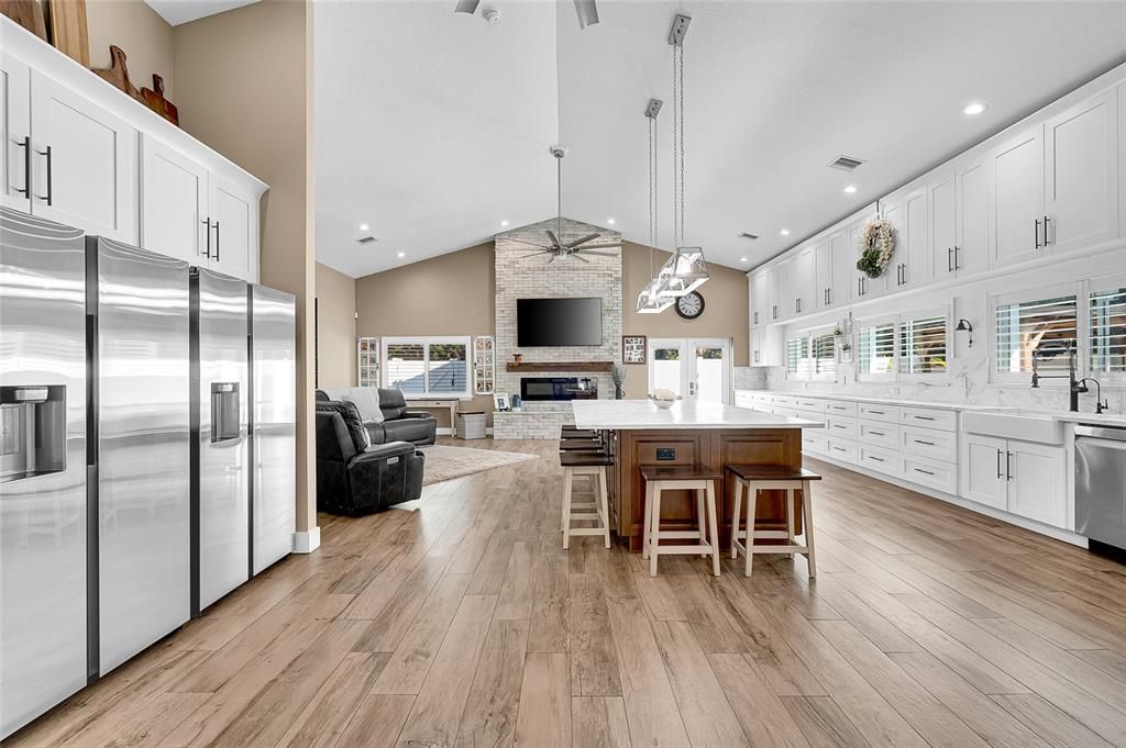 Fireplace, Interior, Kitchen, Living room, Pendant Lights, Recessed Lighting, Stainless Steel Appliances, Stone Walls, Wood Texture Flooring