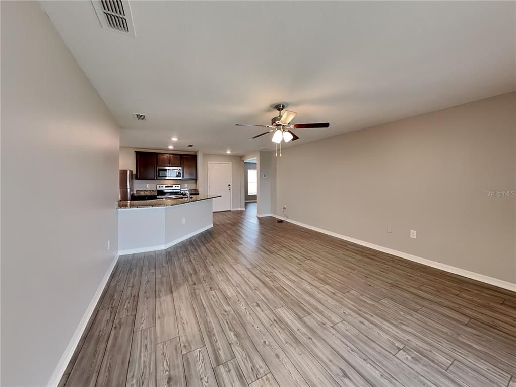 Empty room, Interior, Kitchen, Recessed Lighting, Stainless Steel Appliances, Wood Texture Flooring