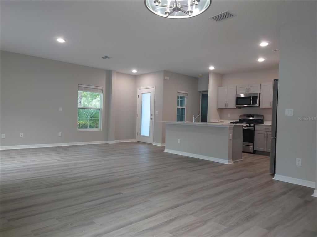 Empty room, Interior, Kitchen, Recessed Lighting, Stainless Steel Appliances, Wood Texture Flooring