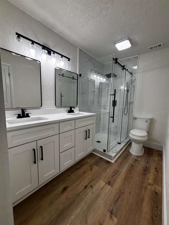 Bathroom, Dual Sink Vanities, Glass Shower, Interior, Marble Walls, Wood Texture Flooring